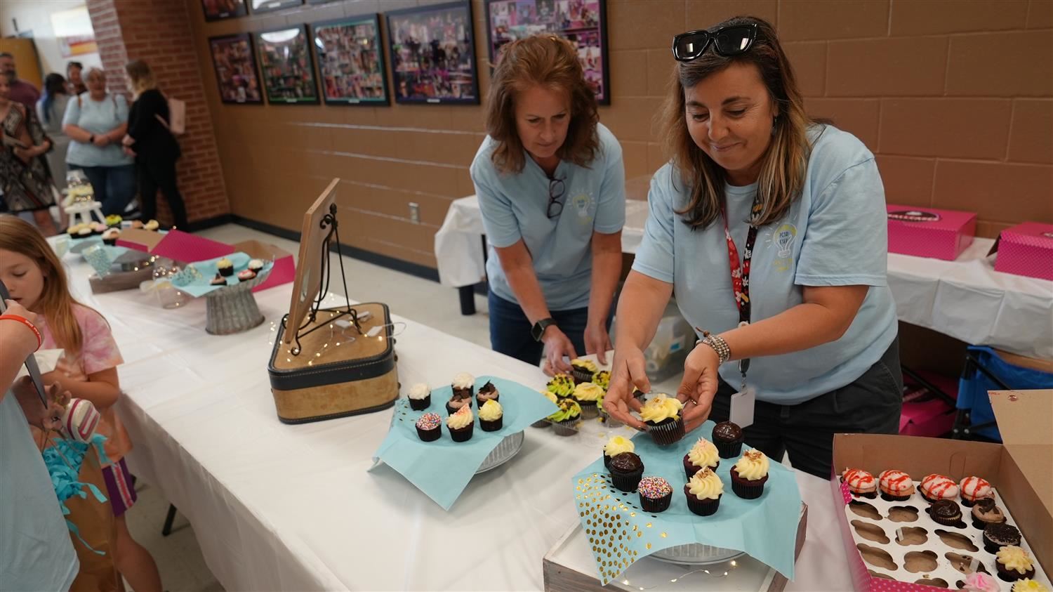 PSCD Student Services employees serving cupcakes to guest